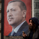 People walk past a large banner showing the portrait of Turkish President Recep Tayyip Erdogan in Taksim Square on March 13, 2017 in Istanbul, Turkey (Photo by Chris McGrath/Getty Images)